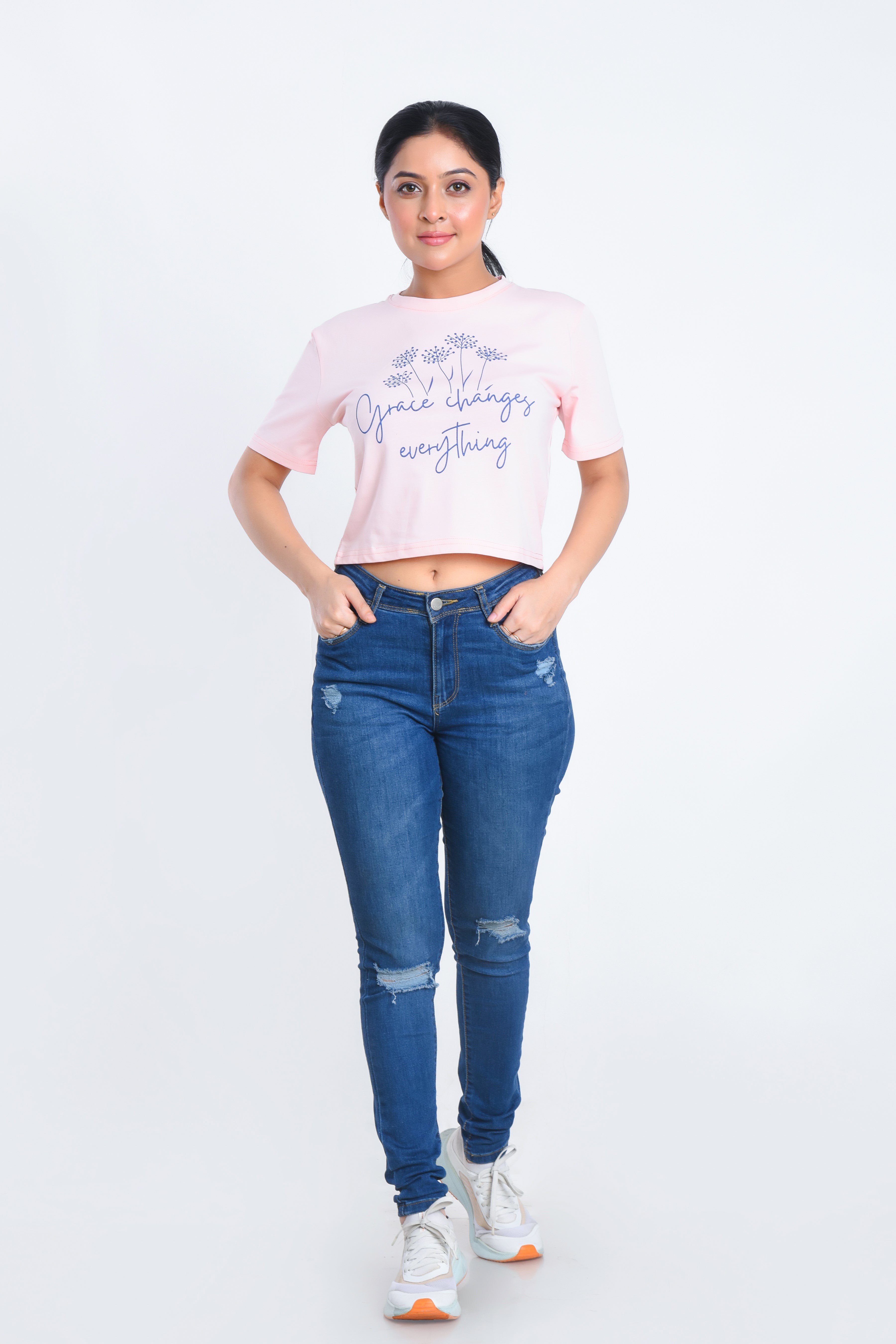 Model Posing in Light Pink Printed Crop Top paired with jeans