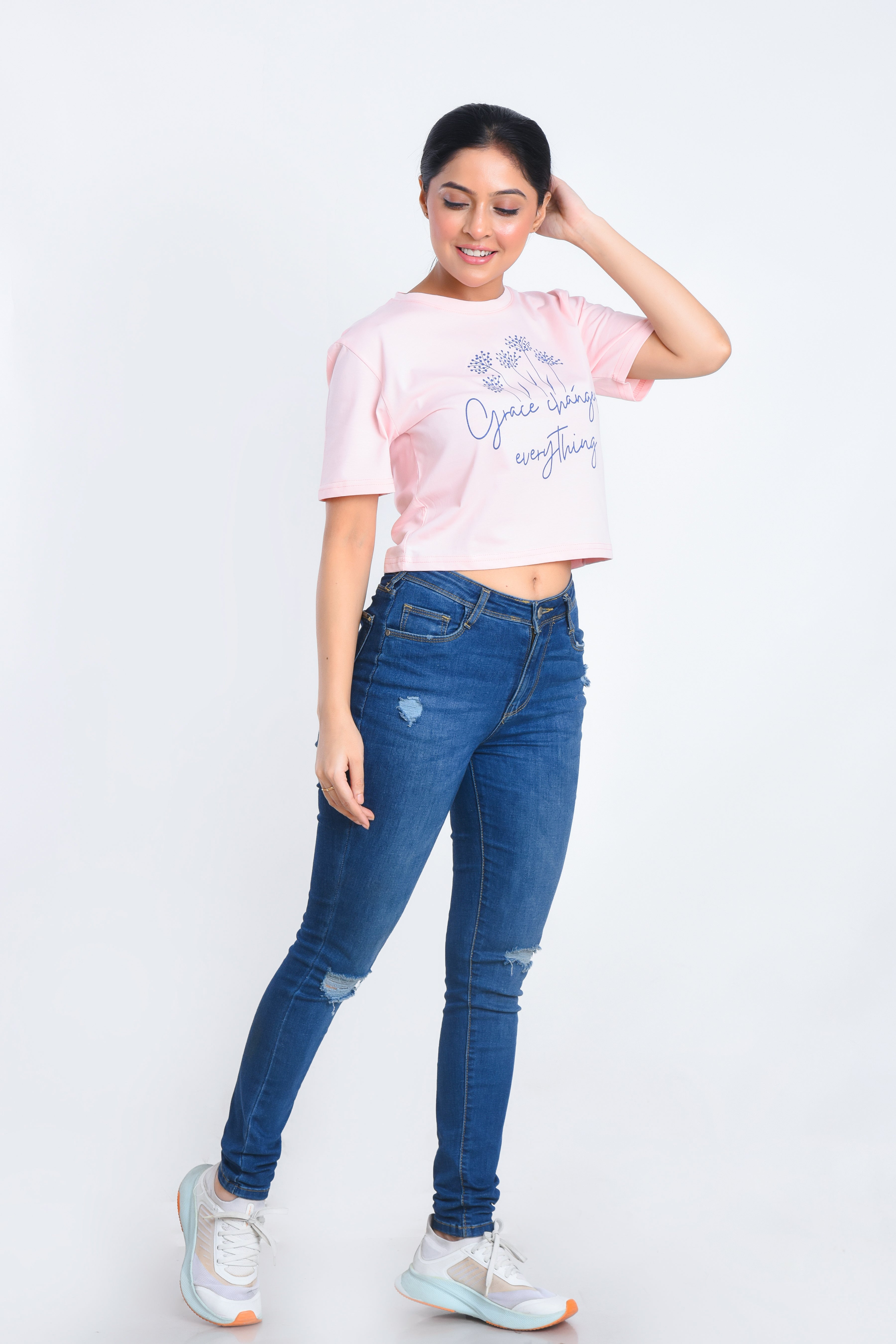 Model Posing in Light Pink Printed Crop Top paired with jeans