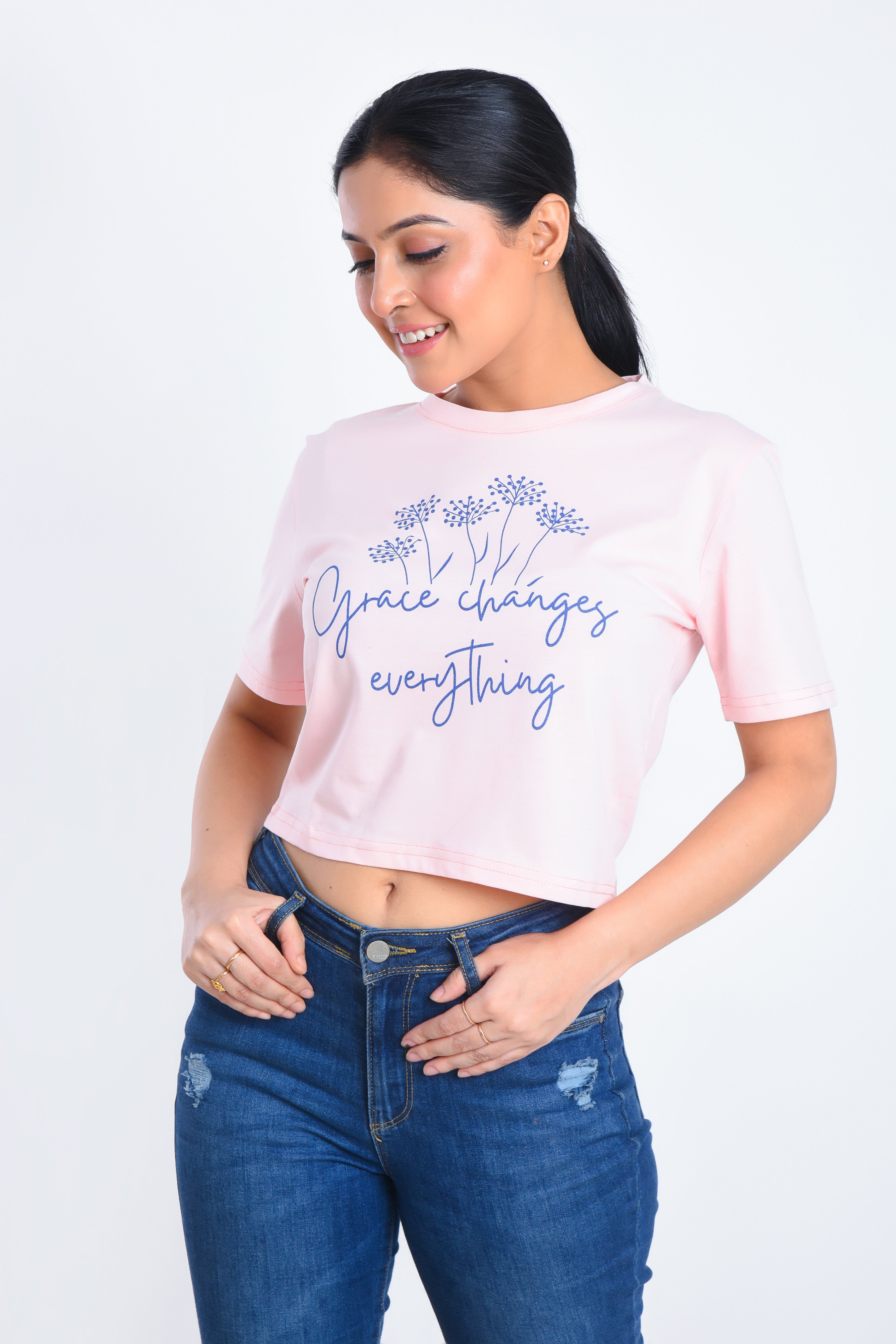 Model Posing in Light Pink Printed Crop Top paired with jeans
